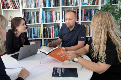 Personer der diskuterer DI2X Frameworks med Pernille Kræmmergaard bøger